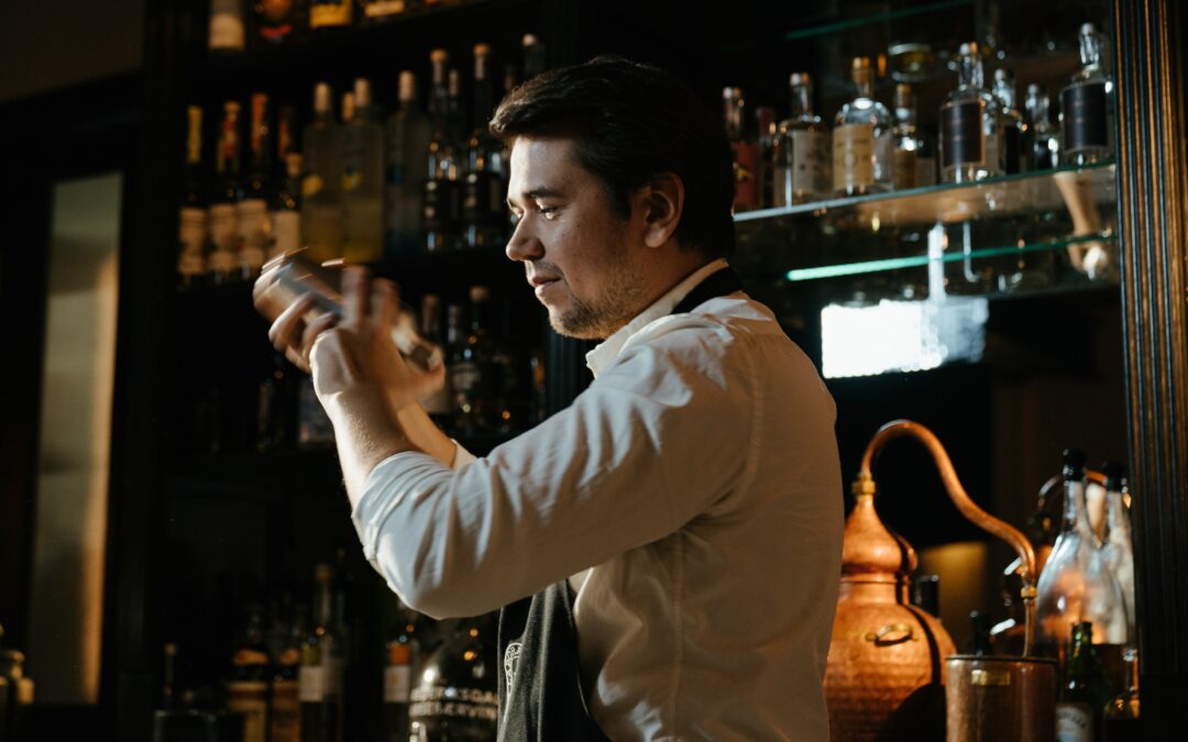 Bar man mixing a cocktail behind a bar - casual bar staff jobs at Beyond Bar Hire